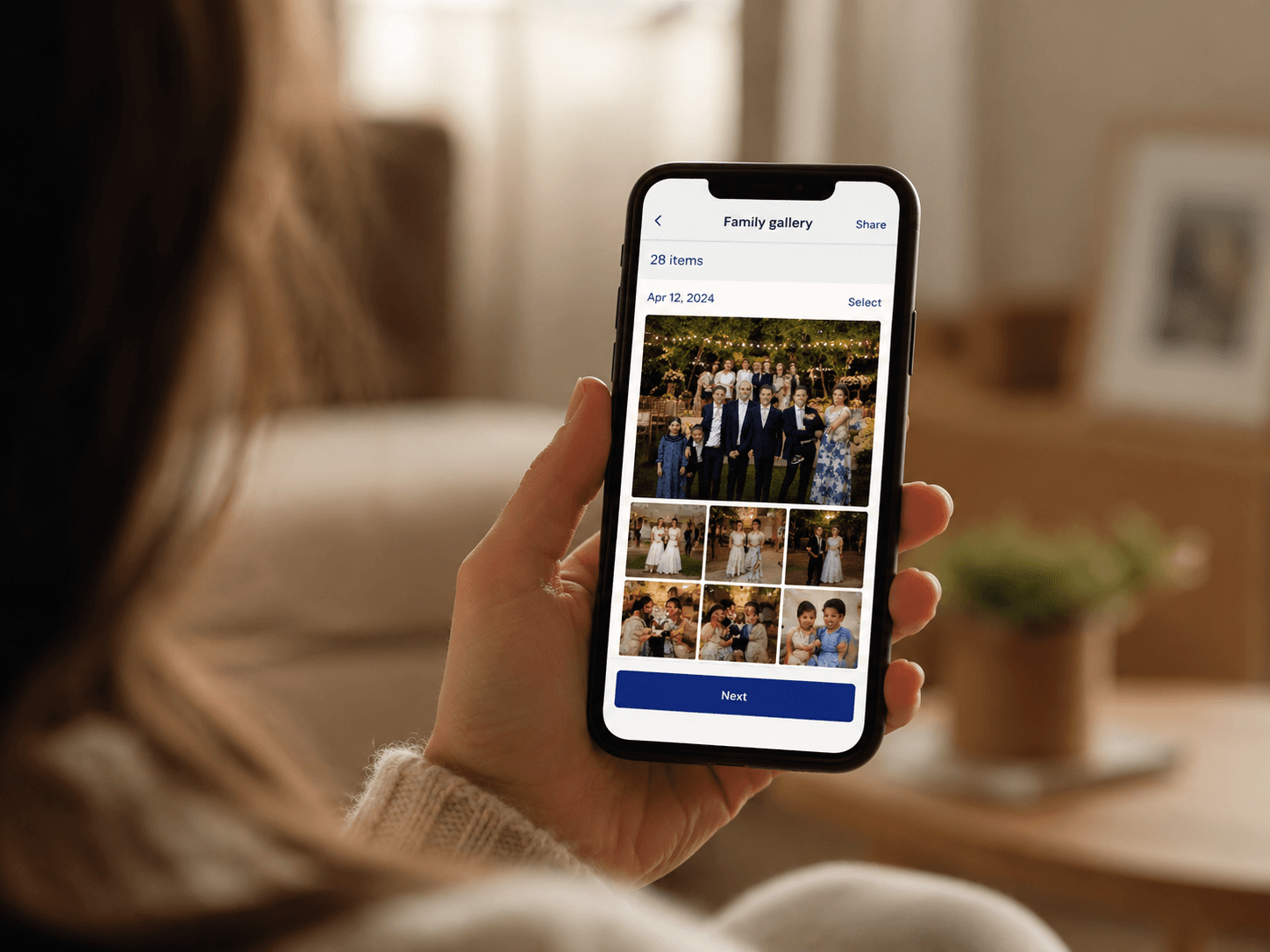 Une main tient un téléphone affichant la galerie de photos de la famille
